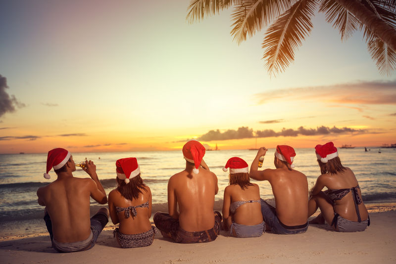 海滩上一群戴着圣诞老人帽的朋友