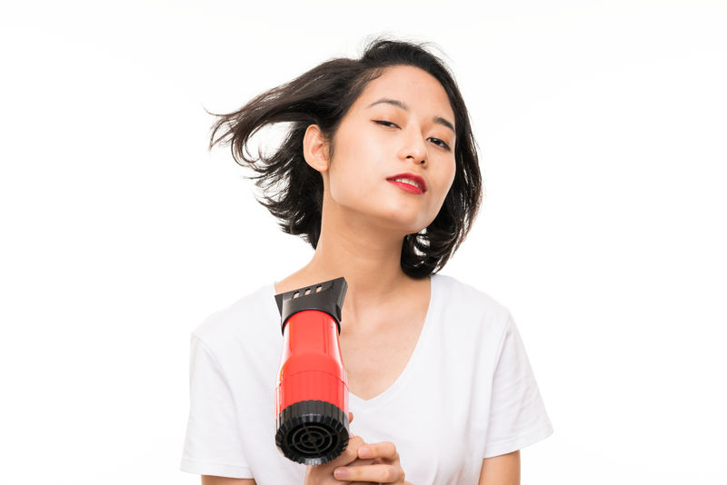 亚洲年轻女子独立背景带吹风机