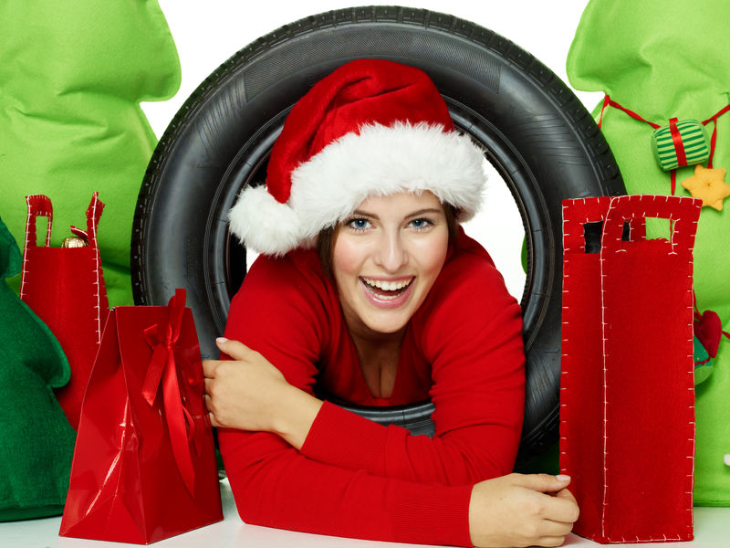 带着轮胎和圣诞礼物的圣诞老人小姐