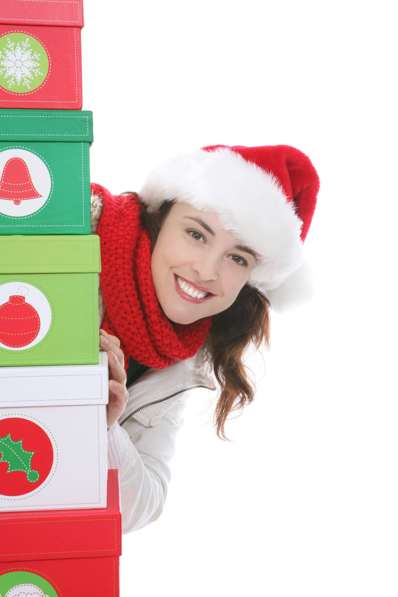圣诞节时一个漂亮的女人躲在礼物后面