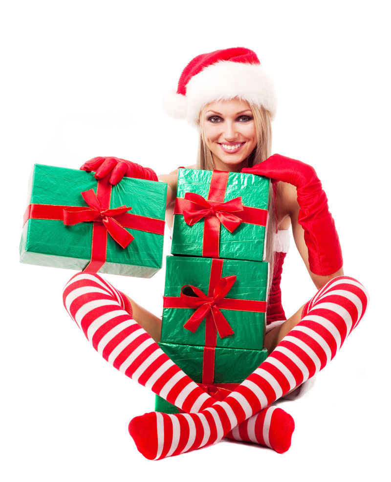 漂亮的金发女郎打扮成圣诞老人给我们很多礼物与白色背景隔离开来