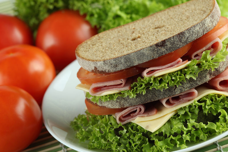 三明治配意大利香肠奶酪和沙拉-整体卷成卷-木底啤酒杯