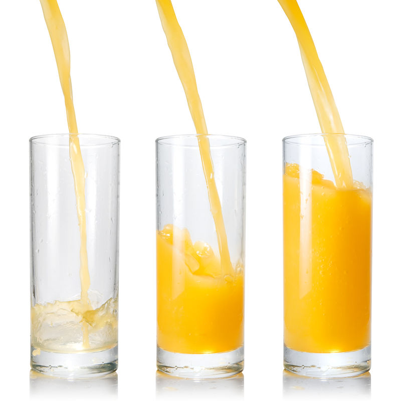 把橙汁倒进白底玻璃里