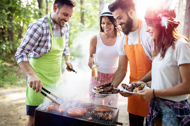 朋友们在大自然中烧烤和吃午餐