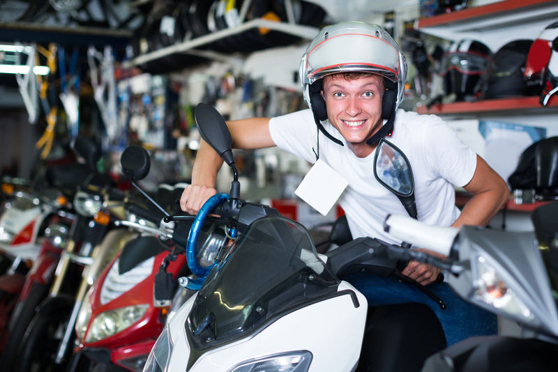 戴头盔的年轻人坐在摩托车上