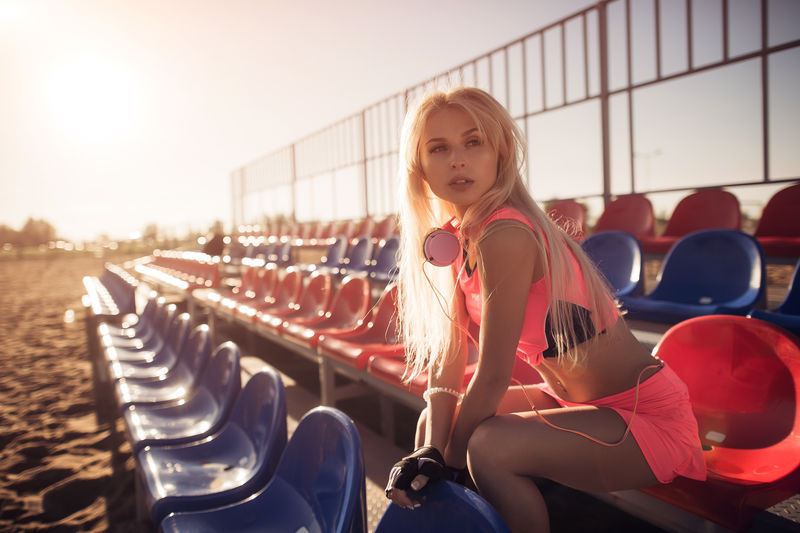 迷人的女选手坐在沙滩上在密集的排球比赛后休息女选手在夏季的背景下