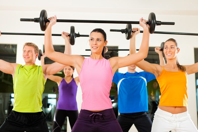 五人行使在健身房或健身俱乐部的杠铃获得力量和健康组