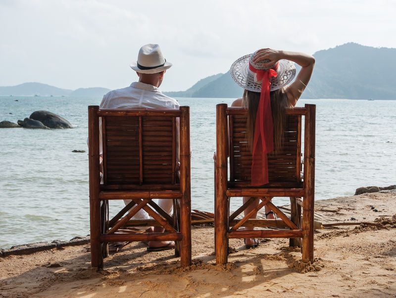 男人和女孩坐在海滩上
