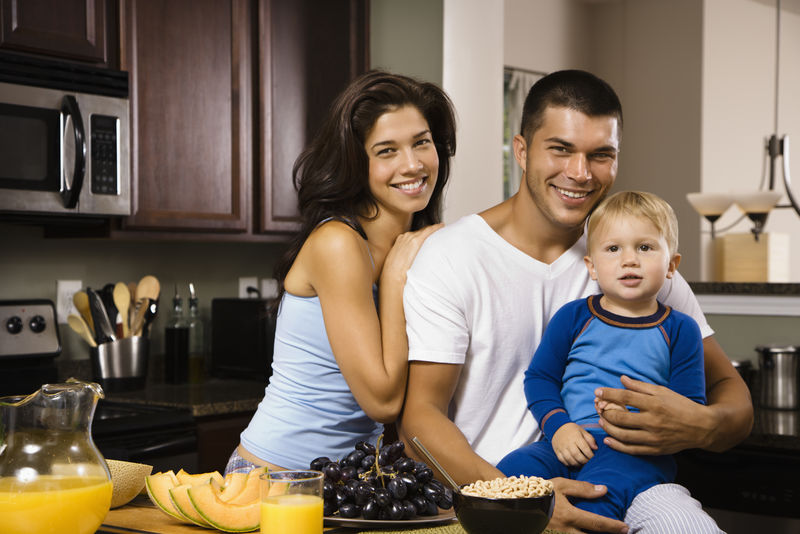 高加索家庭与幼儿在厨房早餐在观众微笑