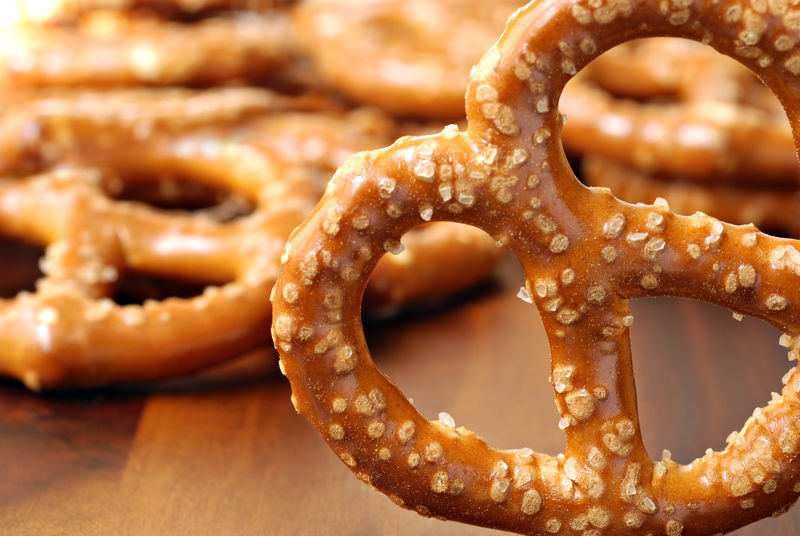 近距离选定的椒盐卷饼-背景中有柔和焦点的其他椒盐卷饼-具有极浅自由