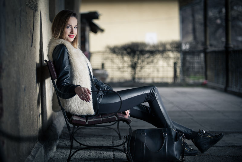 站在火车站上的漂亮的浅棕色女人-带着她的行李画像