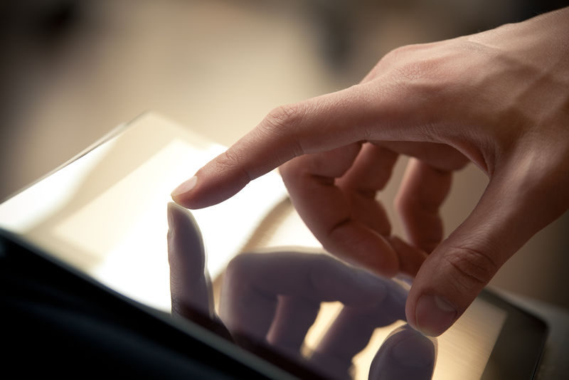 现代数字平板电脑上的手动触摸屏-用浅景深聚焦在手指上的近距离图像