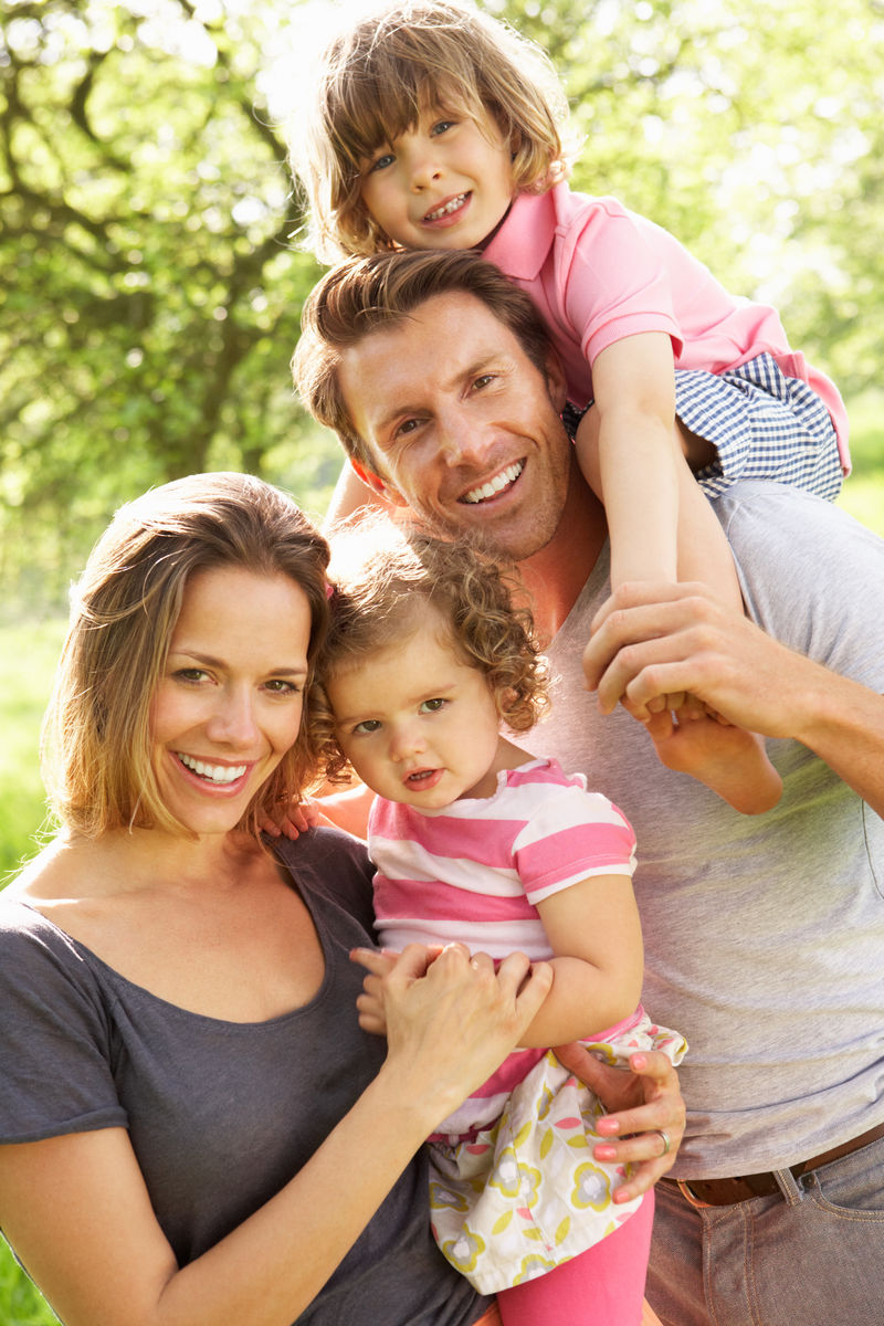 父母们和孩子们站在盛开夏花的田野里