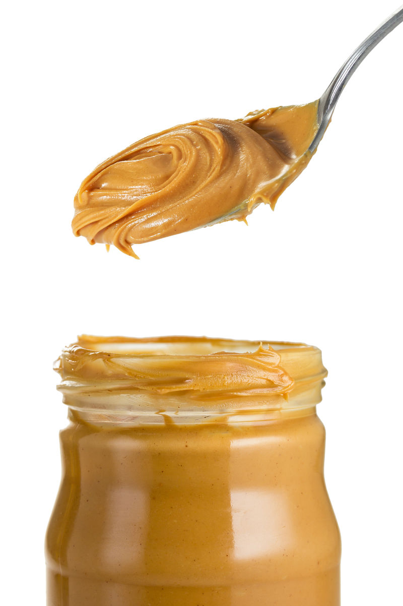 用勺子把花生酱放在罐子里