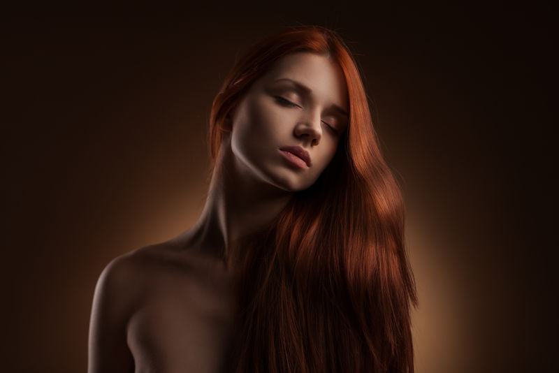 深色画室背景下的长发美女肖像