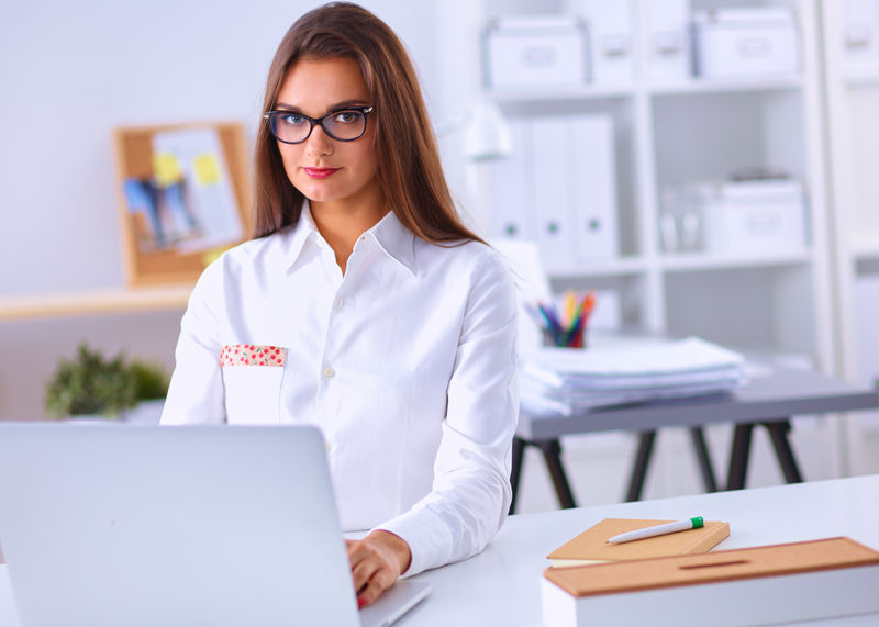 坐在办公室桌子上的漂亮女商人