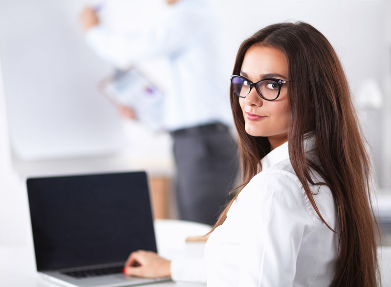 坐在办公室桌子上的漂亮女商人