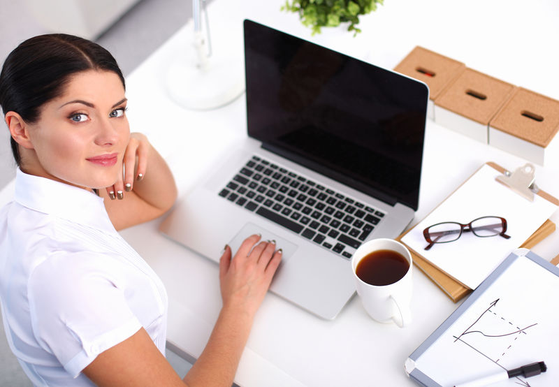 坐在办公室桌子上的漂亮女商人