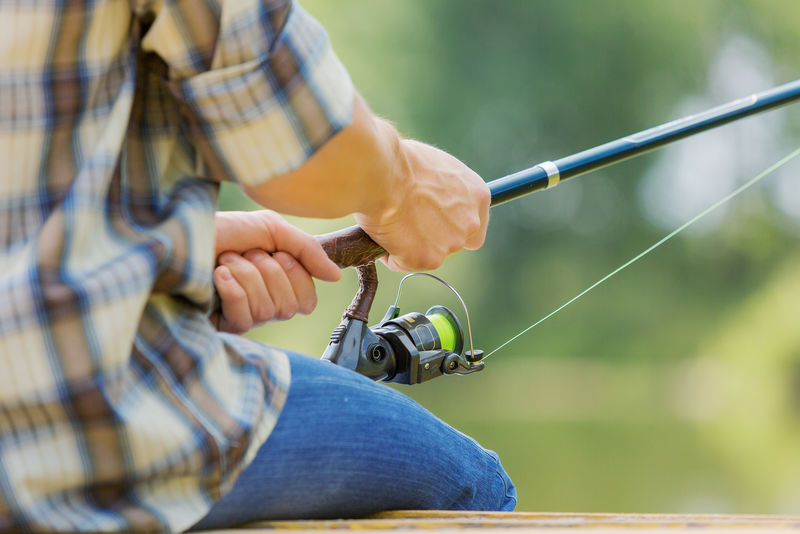 坐在桥上钓鱼的人的特写镜头