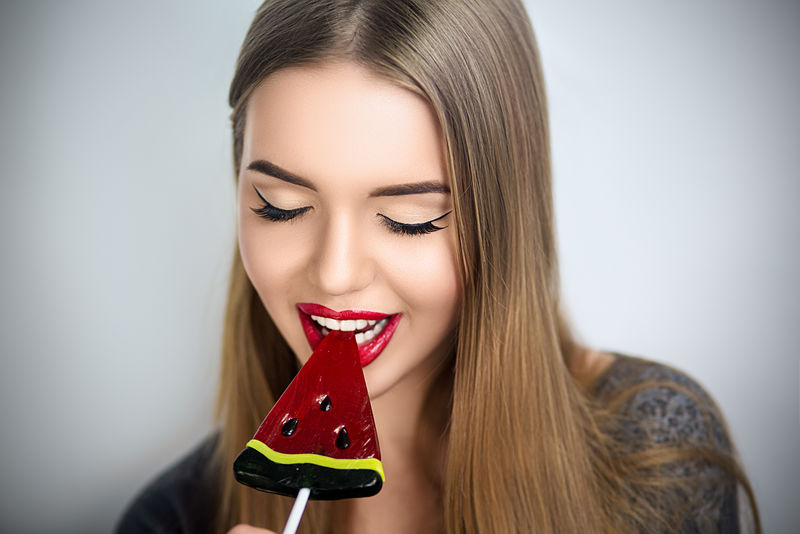 吃糖果的性感女人-性感的嘴唇-美甲和唇膏-欲望-美女性感的草莓嘴唇-白牙