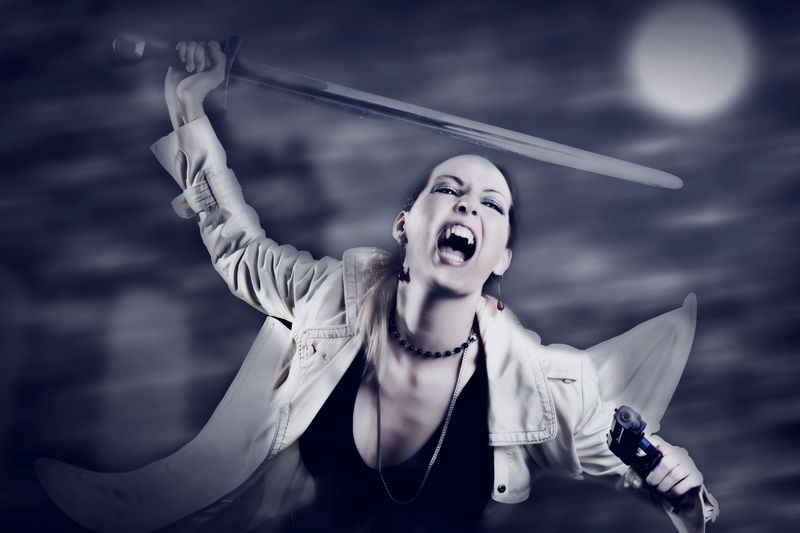 年轻性感女人吸血鬼手持中世纪的剑和枪的画像