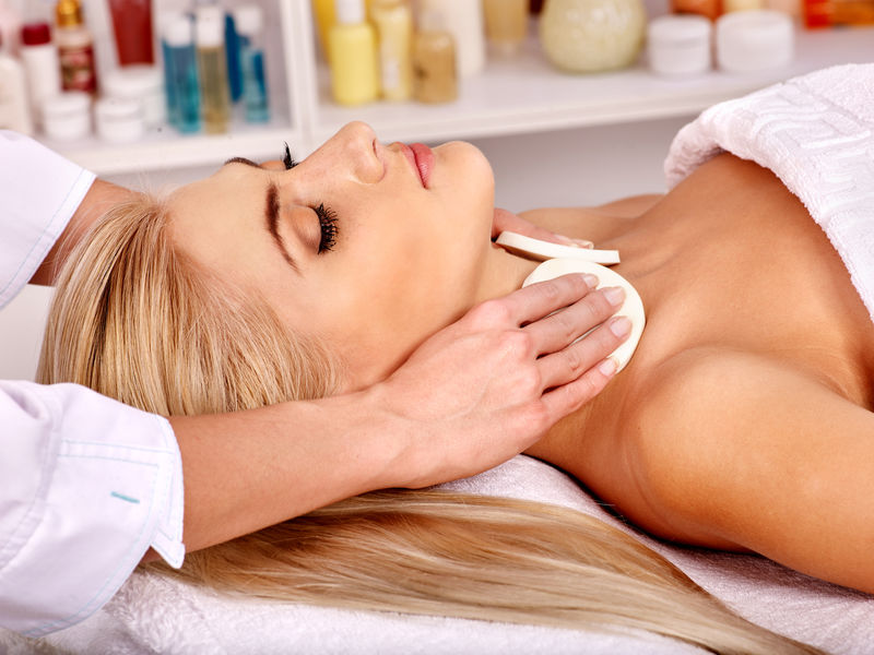 在水疗中心做头部按摩的金发女人