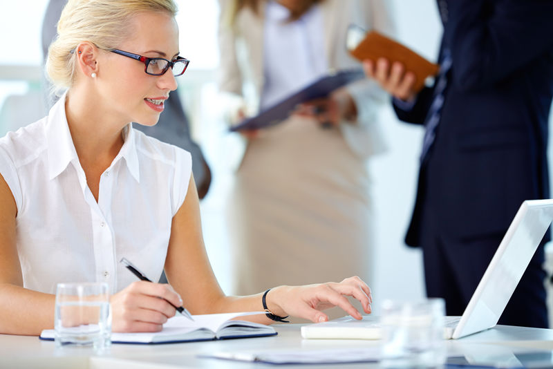 忙碌的秘书在联网时看笔记本电脑的照片