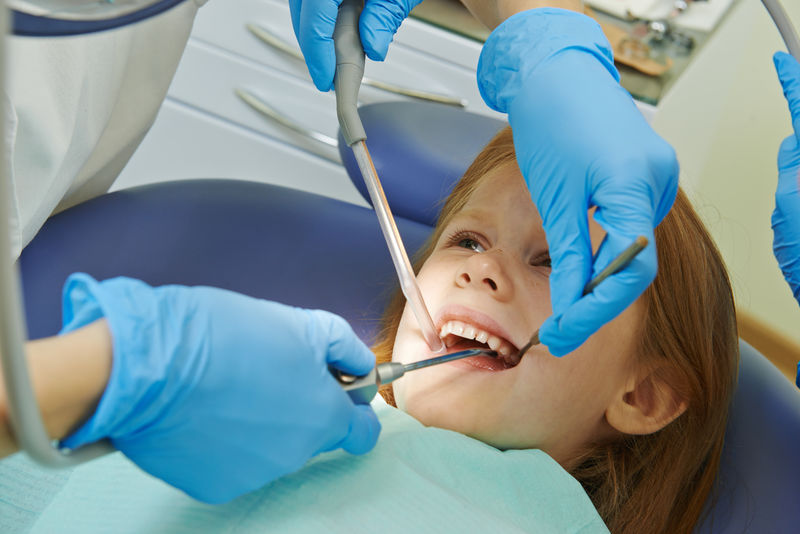 牙科正畸女医生在诊所儿童护理期间用牙科工具进行手部护理