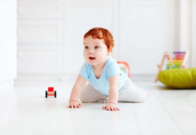 可爱的婴儿在家里爬在地板上