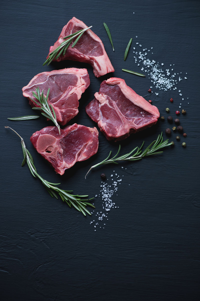 上图：生T骨羊肉牛排，黑色木质背景