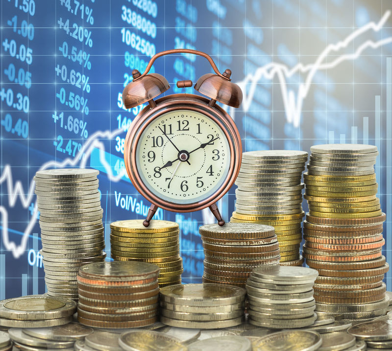 一堆堆的硬币踩着泰铢,上面有老式的时钟。