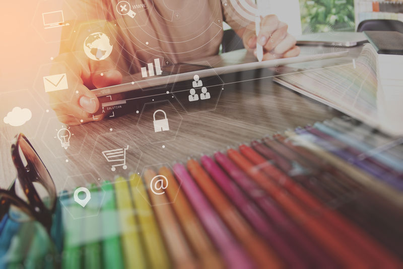 商人在现代办公室的木制办公桌上使用智能手机和笔记本电脑，带有虚拟图标界面