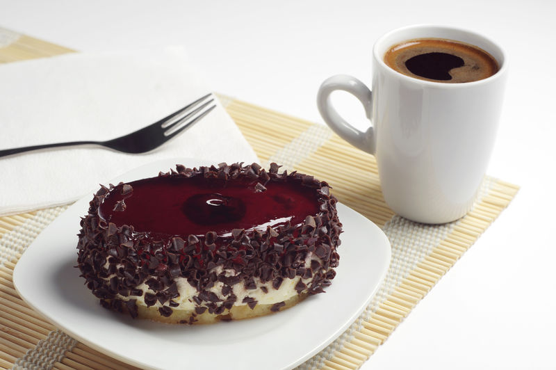 樱桃果冻巧克力蛋糕和竹餐巾热咖啡