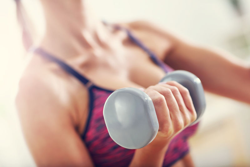 女人在家用哑铃锻炼