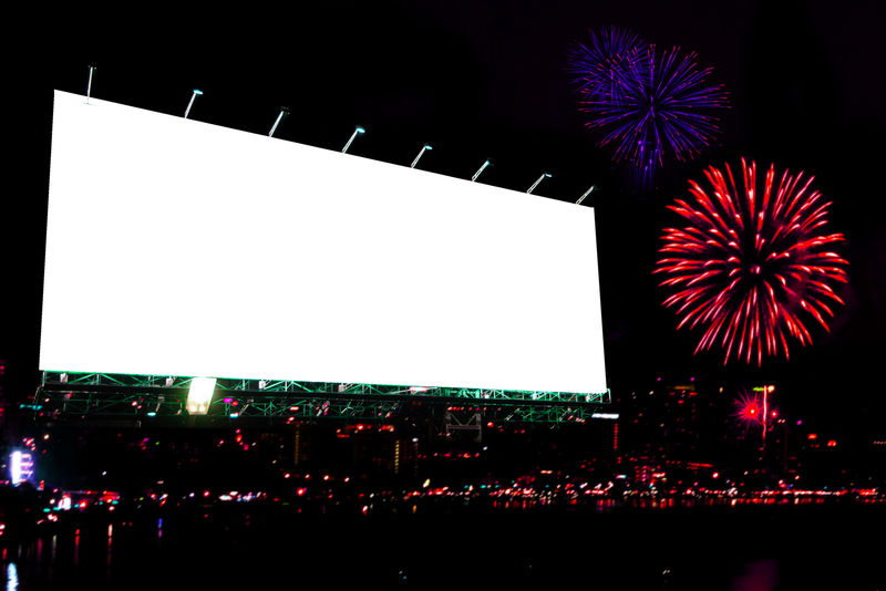 夜晚燃放烟花的空白广告牌
