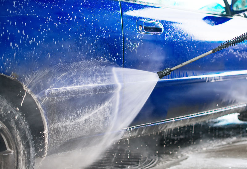 使用高压水射流清洗蓝色汽车