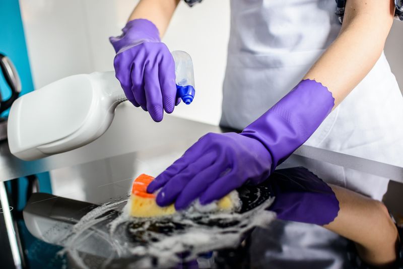 女士用橡胶防护手套清洁厨房台面