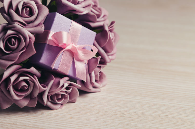 紫玫瑰和木面粉红丝带礼品盒