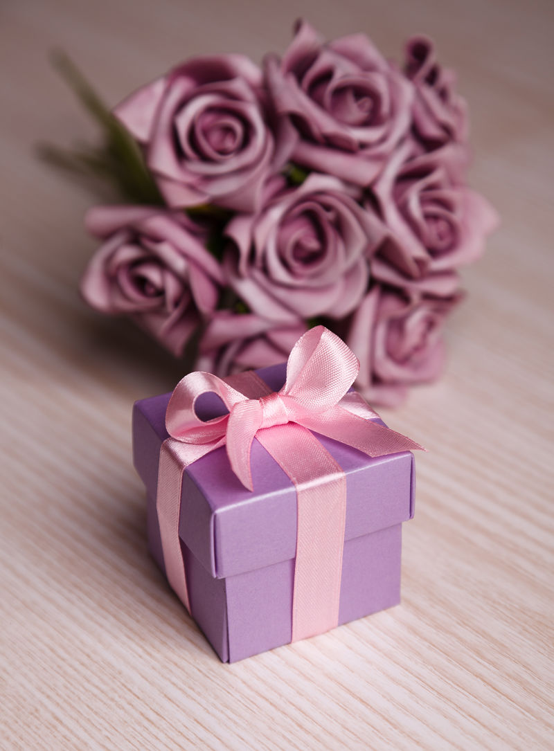 紫罗兰玫瑰和木面粉红丝带礼品盒