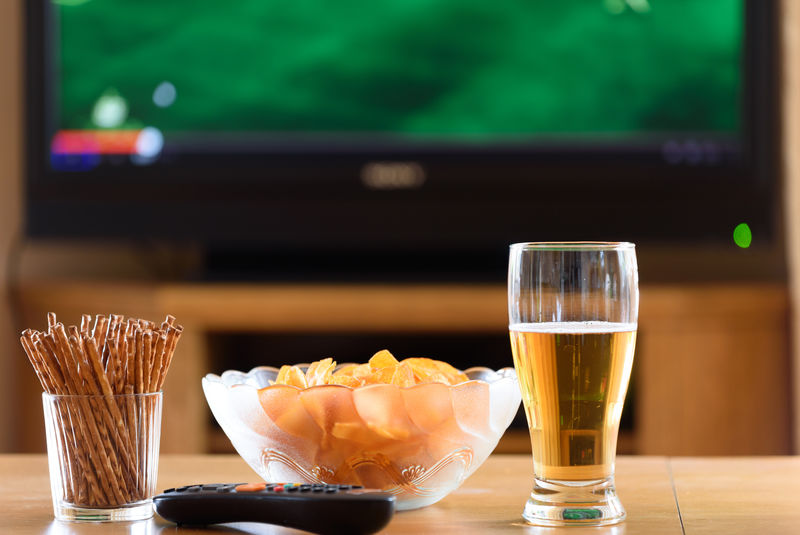 电视、电视（足球、足球比赛）和桌上小吃-库存照片