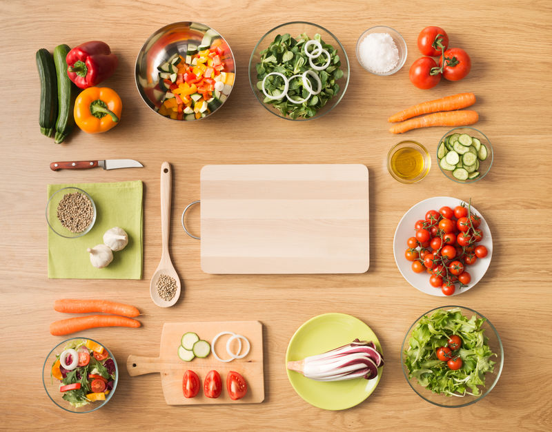 创意素食在家烹饪概念与新鲜健康蔬菜切碎-沙拉和厨房木器-顶视图与复印空间