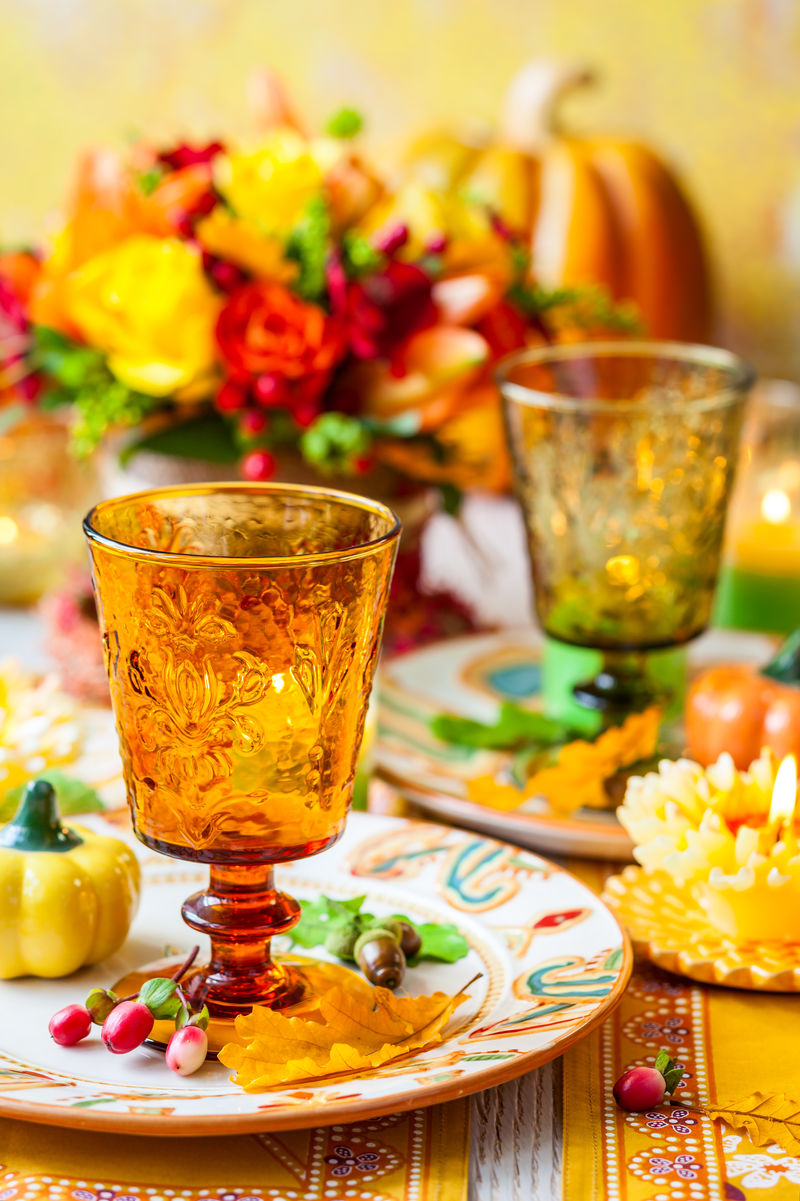 盛开秋花、蜡烛和南瓜的节日餐桌