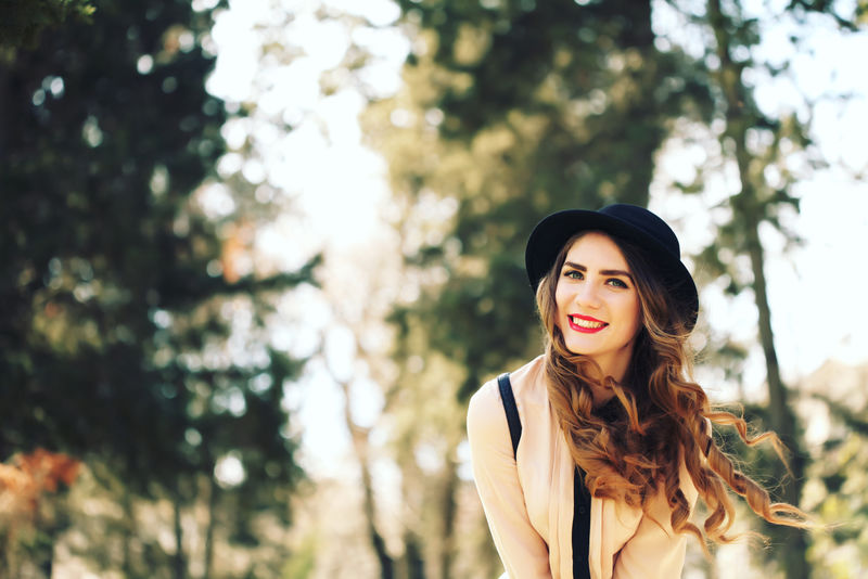 快乐、消费、时尚和人的概念——阳光下的户外城市背景下微笑的年轻时髦时髦女孩