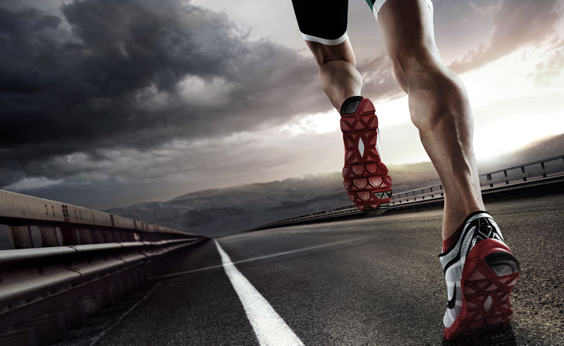 运动-跑步者的脚在公路上奔跑-在鞋子上特写