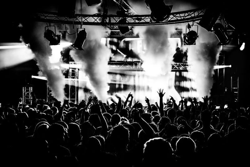 在奶油夜总会的派对上-黑白两色的观众围成剪影-向DJ皮特唐跳舞-夜生活中的激光手举着烟雾炮在空中爆炸