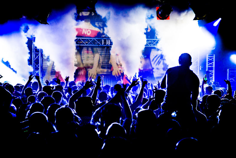 在奶油夜总会派对上-观众们围成一个肩并肩的人-向DJ皮特唐跳舞-夜生活中的激光手举着烟雾炮在空中爆炸