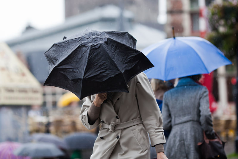 雨中城市里带着雨伞行走的人们