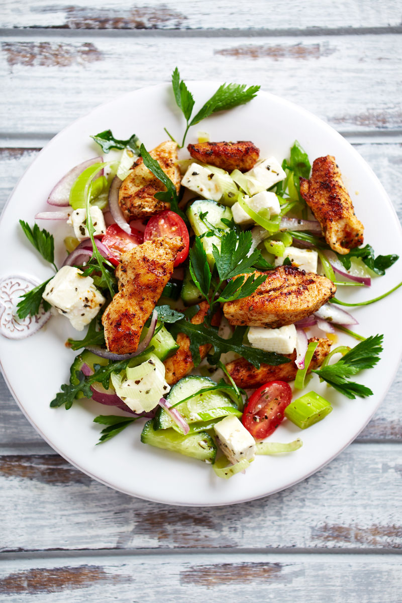 鸡肉色拉配费塔奶酪、樱桃番茄、韭菜、黄瓜、红洋葱、芝士和新鲜欧芹-自制食物-美味健康的概念-白色木质背景-顶视图