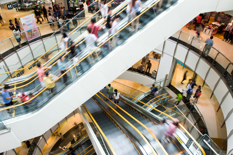 人们在现代购物中心的自动扶梯里活动