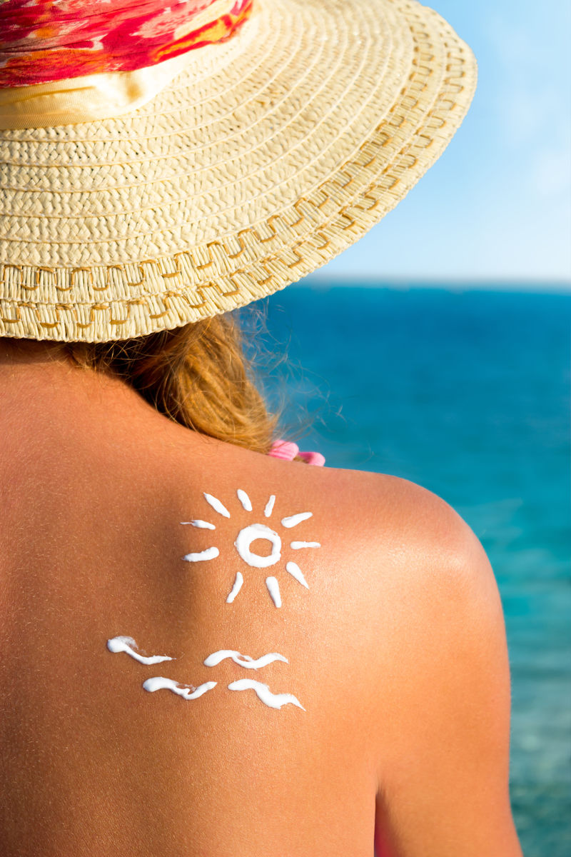 防晒霜/防晒霜-阳光下的女人-比基尼女孩坐在沙滩上晒太阳
